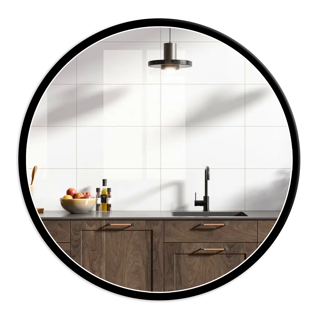 Modern kitchen scene: white tiled wall, dark countertop, wood cabinets, black faucet, fruit bowl and oil bottles on the counter.