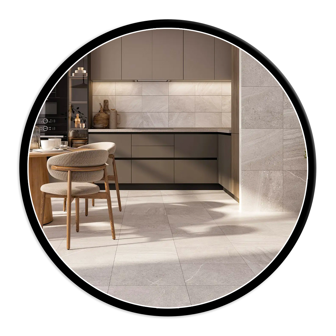 Modern beige kitchen with lower and upper cabinets, marble backsplash, and a round wooden dining table with upholstered chairs nearby.