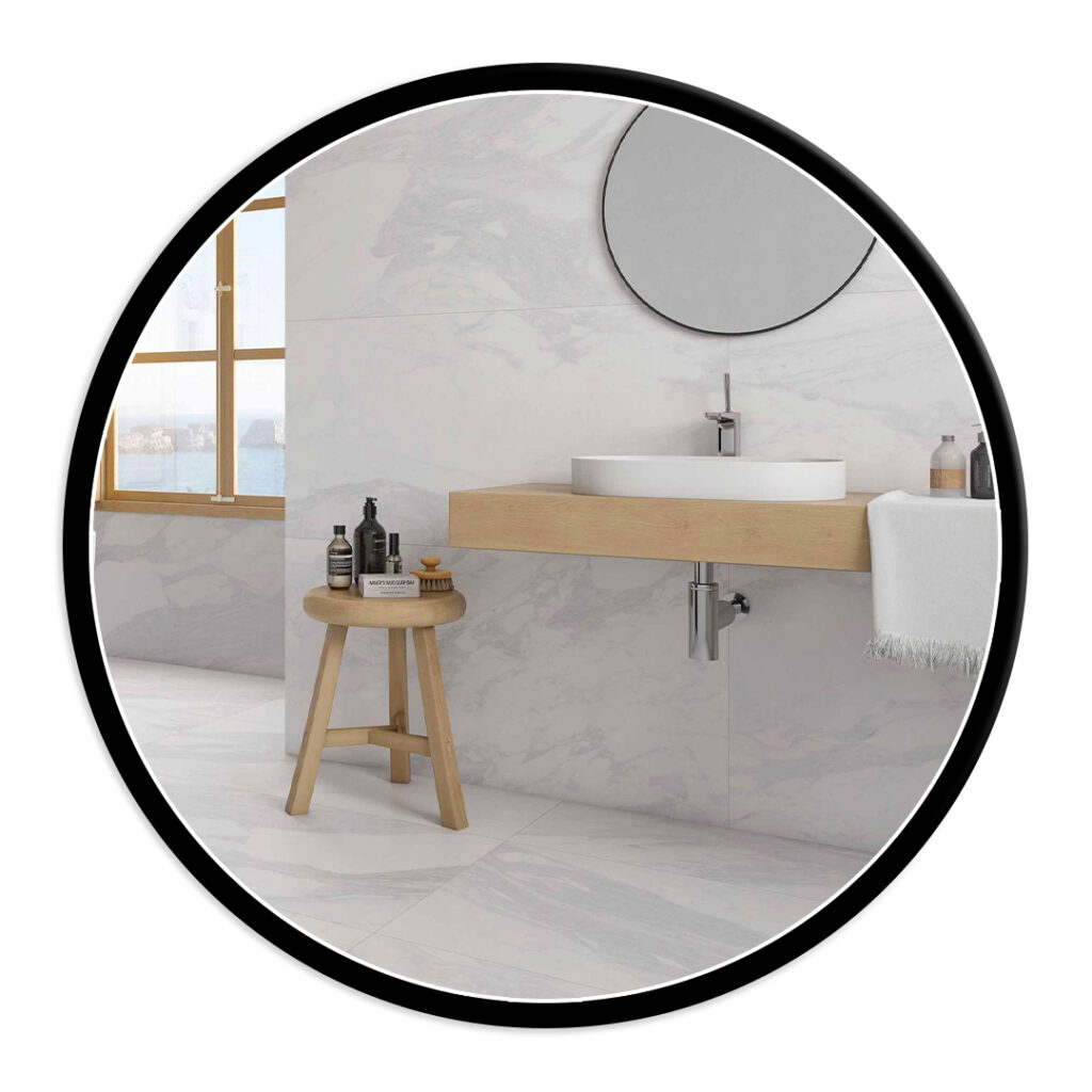 Modern bathroom with marble walls, round vessel sink on a wooden vanity, circular mirror, and a wooden stool with bottles on top.
